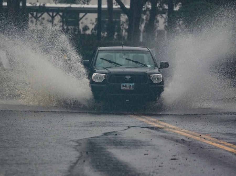 I veicoli attraversano una strada parzialmente allagata a Dunedin prima dell’arrivo dell’uragano Milton previsto stasera in Florida. (Photo by Bryan R. Smith / AFP)