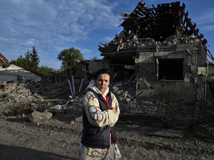 Una donna cammina accanto a una casa gravemente danneggiata da un attacco aereo russo,  a Zaporizhia. (REUTERS/Stringer)