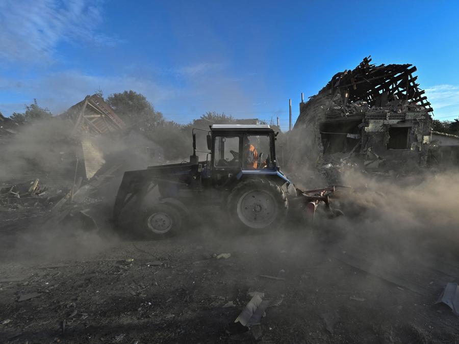 Un lavoratore comunale pulisce un’area residenziale colpita da un attacco aereo russo,  a Zaporizhia. (REUTERS/Stringer)