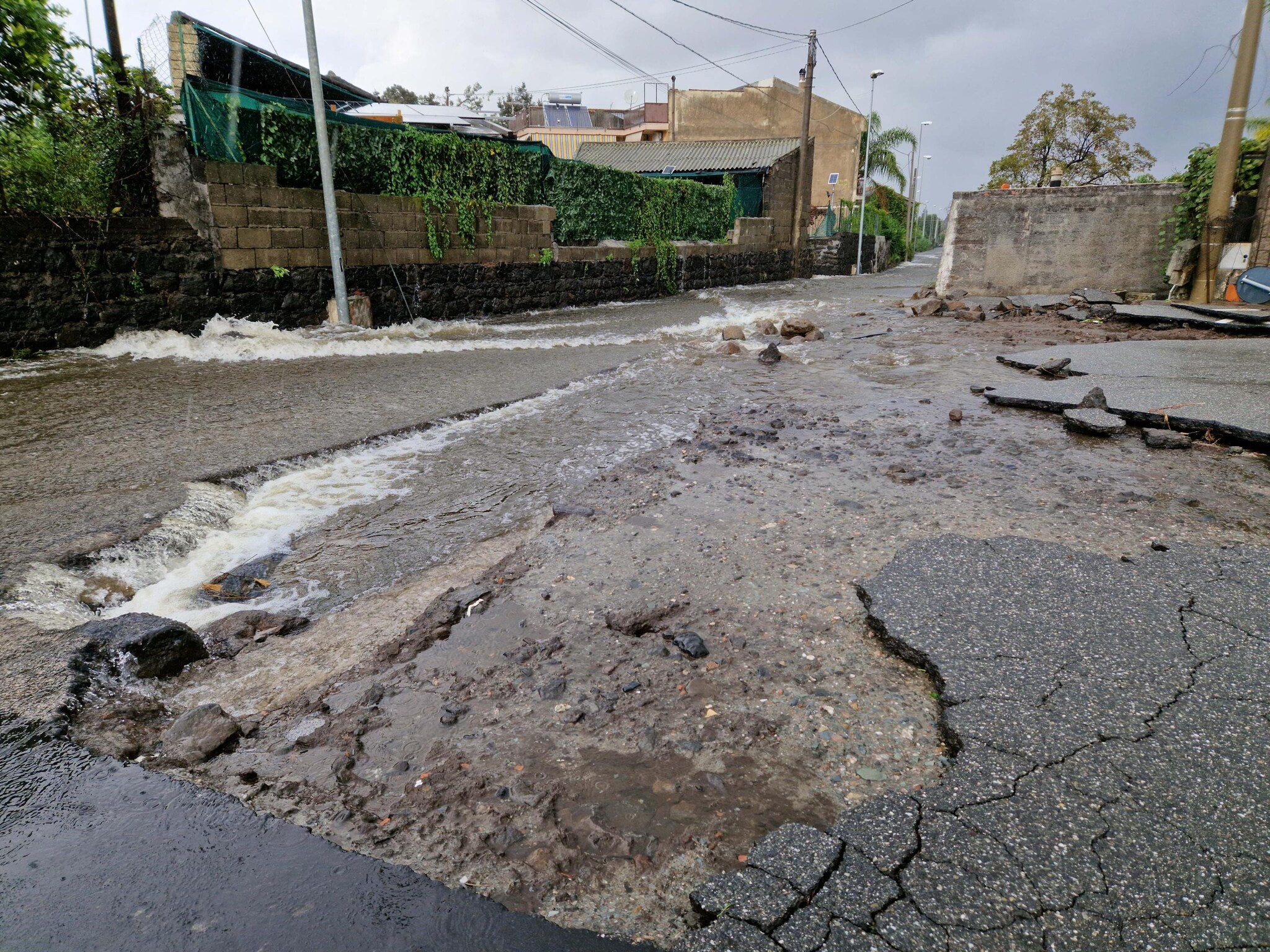 Voragine in una strada dopo l'esondazione di un fiume ad Altarello, frazione di Riposto, Catania, 13 novembre 2024. (Ansa, Orietta Scardino)