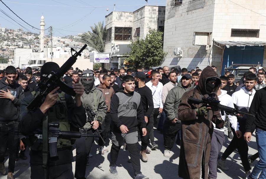 Miliziani palestinesi mostrano le loro armi durante il funerale dei palestinesi uccisi durante le operazioni militari israeliane, nel villaggio di Qabatiya, vicino alla città di Jenin, in Cisgiordania. (EPA)