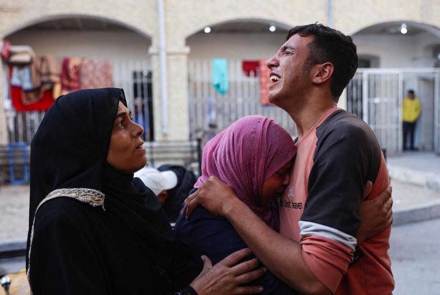 I parenti piangono la morte di Atef Al-Atout, un uomo palestinese  ucciso mentre fuggiva da Beit Lahia, nel nord della Striscia di Gaza. (AFP)