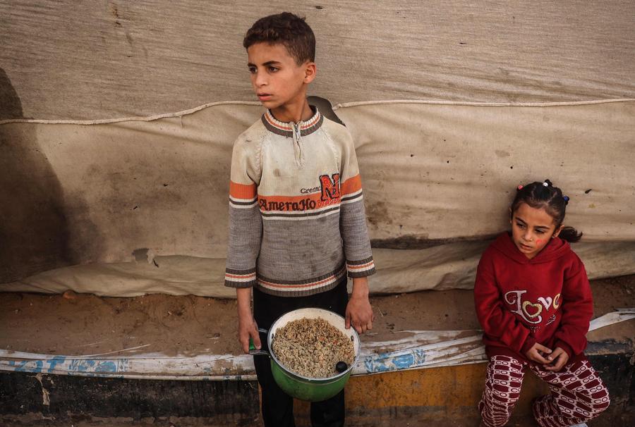 Bambini palestinesi raccolgono aiuti alimentari nel campo profughi di Bureij, nel centro della Striscia di Gaza. (AFP)