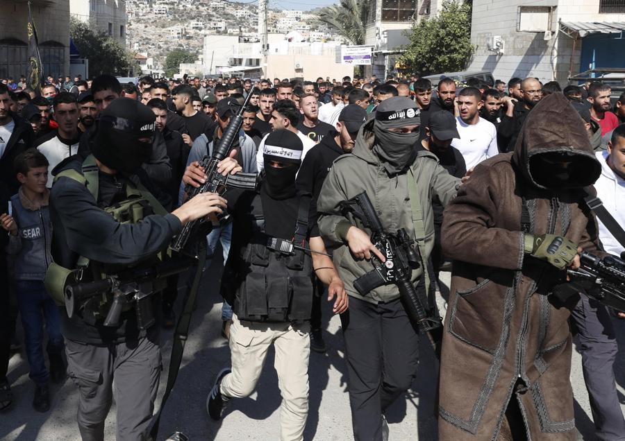 Miliziani palestinesi mostrano le loro armi durante il funerale dei palestinesi uccisi durante le operazioni militari israeliane, nel villaggio di Qabatiya, vicino alla città di Jenin, in Cisgiordania. (EPA)