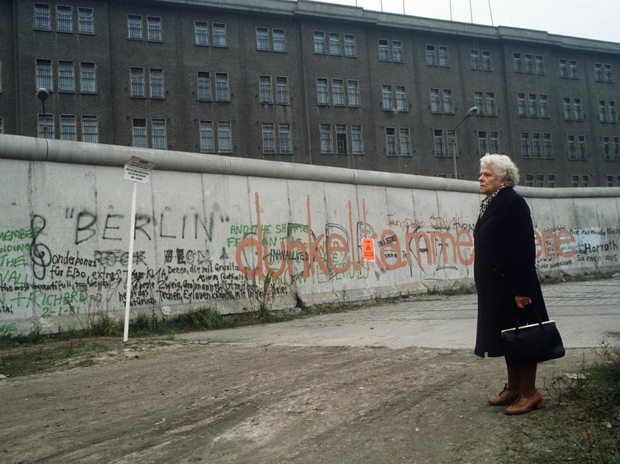 Muro di Berlino Ovest. Pochi anni prima della distruzione, un'anziana signora guarda il muro che divide la città in due blocchi, coperto di scritte. Berlino, 1985 circa. Fototeca Gilardi / AGF