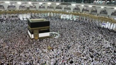 Pellegrini alla Mecca girano intorno alla Kaaba con gli ombrelli