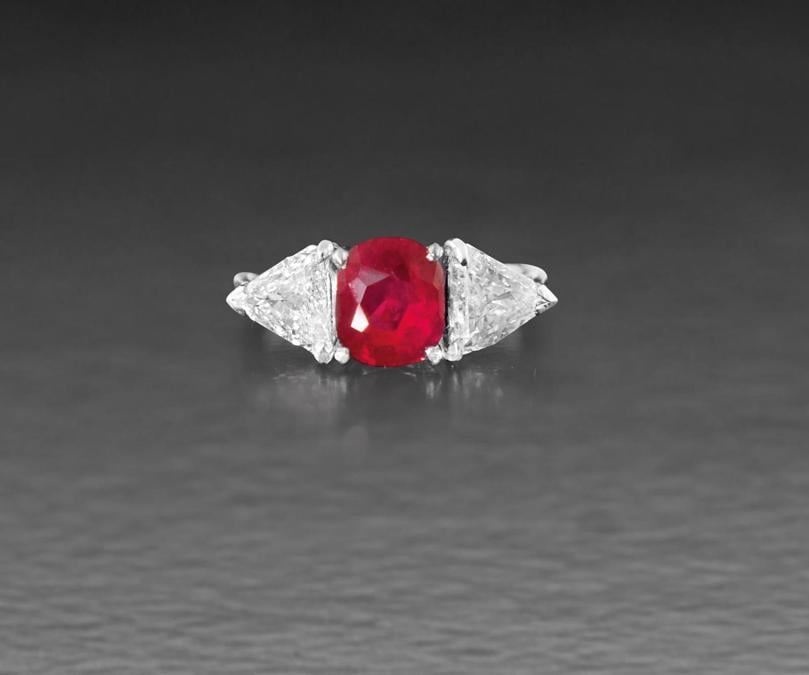 Asta 842 lotto 396 ANELLO. In oro bianco 18 kt centrato da rubino (Burma-Myanmar) taglio cuscino proveniente dalla storica miniera di Mogok di 1,80 ct ca. con nessuna indicazione di trattamento termico, ai lati due diamanti taglio triangolare gradinato per tot. 1,60 ct ca., completo di due certificati gemmologici n. 22931 del 29/09/2016, IGN, Roma e 1803208 del 09/03/2018, Dott. C. Dunaigre, Lucerna. 5,30 g; misura 9. base d'asta: 8.000 € aggiudicato per € 11.685