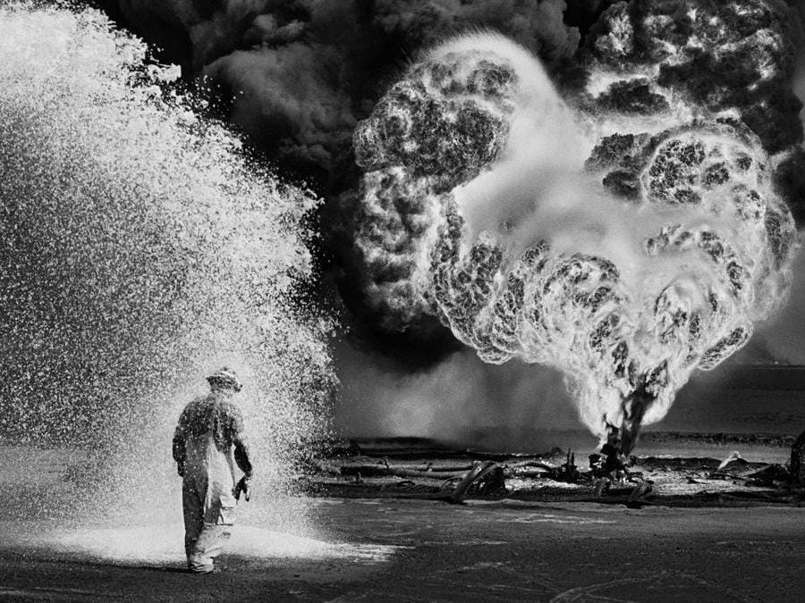 Spray chimici proteggono questo pompiere dal calore delle fiamme. Pozzi di petrolio, Greater Burhan, Kuwait, 1991. © Sebastião Salgado /Amazonas Images/Contrasto