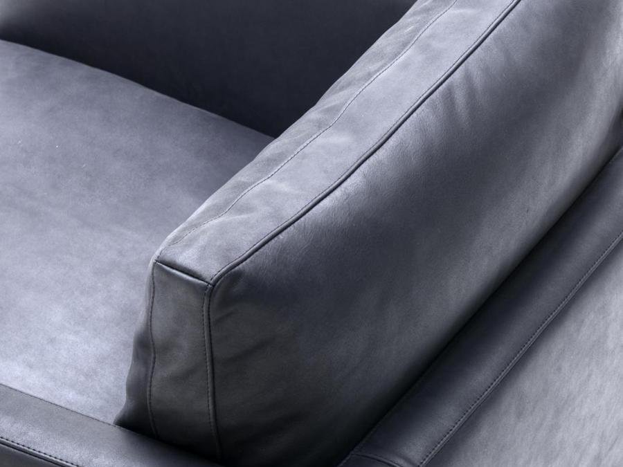 Living Divani, poltrona Dumas, design Piero Lissoni; caratterizzata da una seduta leggermente sporgente, è sostenuta da piedini in legno scuro o metallo brunito. Lo schienale basso, da cui emerge un morbido cuscino, si raccorda al bracciolo dolcemente curvato. 