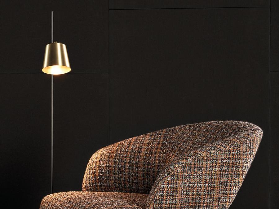 Large Armchair, Creed Collection, design Rodolfo Dordoni; appoggia a terra a mezzo di un supporto in metallo curvato e verniciato lucido color bronzo chiaro, mentre nella parte anteriore appoggia su gambe in massello di legno Sucupira tinto visone. 