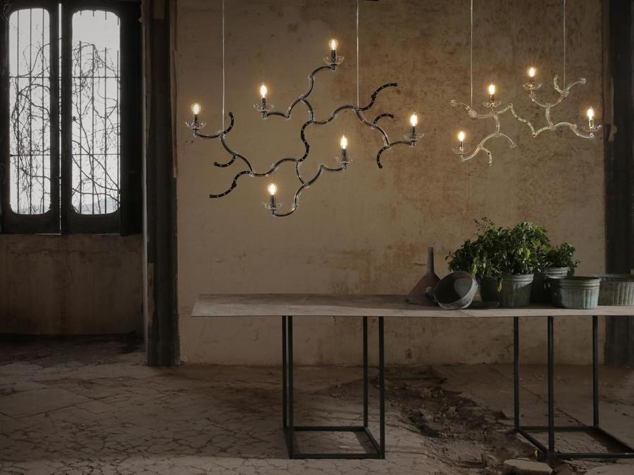 Karman, chandelier Ghebo, design Luca de Bona e Dario De Meo; si basa sulla scomposizione degli elementi essenziali che costituiscono un classico lampadario Maria Teresa, rivisitato in chiave bidimensionale. È composto da elementi in metallo e vetro di Murano.