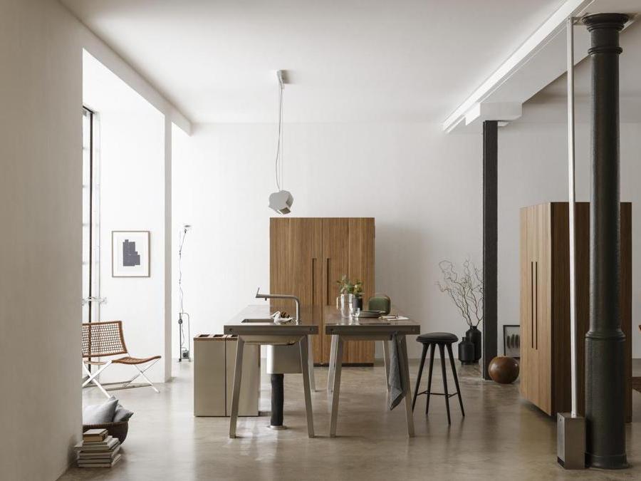 Bulthaup, b2. La cucina è costituita da tre elementi monolitici indipendenti: stazione di lavoro, che riunisce in sé punto acqua, punto cottura, la zona di lavoro e non da ultimo la zona pranzo; madia di contenimento, a una o due ante; stazione per gli elettrodomestici, per contenere dietro alle ante, forno, lavastoviglie e frigorifero. Questi tre moduli non richiedono un appoggio a elementi statici consentendo estrema flessibilità e mobilità