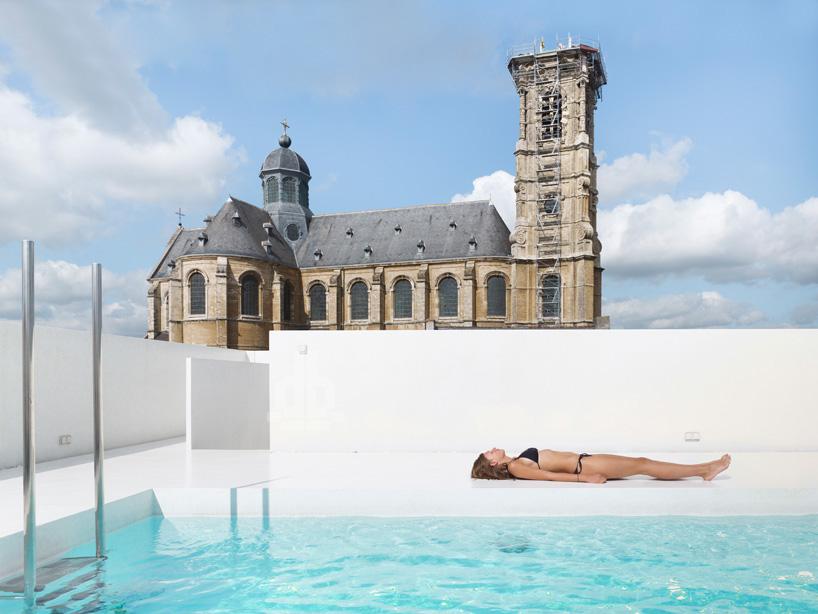 Pool K, DMVA, una piscina rettangolare sul tetto di un antico edificio del 17° secolo in una cittadina delle Fiandre in Belgio, la cui privacy è protetta da muri candidi come l'intera area; è importante sapere che, per sostenere il notevole peso, è stata installata una struttura di travi e pilastri in cemento armato. Per chi dispone di un appartamento all'ultimo piano, con la possibilità di proteggere la privacy in modo raffinato.