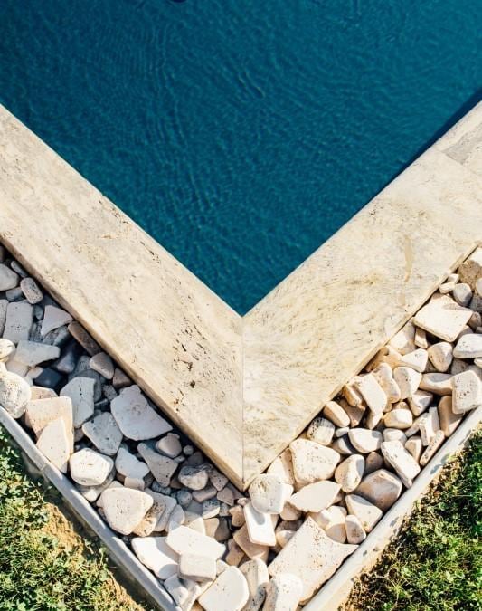 Progetto Ambiente, Premio Italia Awards 2017 per la categoria residenziale outdoor, piscina geometrica, rettangolare, con bordo in marmo, con selciato e tappeto erboso in un mix di grande eleganza. A causa della carenza idrica della zona, i progettisti hanno previsto due vasche per avere un accumulo d'acqua piovana da utilizzare per la piscina, in caso di necessità. Il lusso di una piscina sempre pronta anche in zone con approvvigionamento idrico critico.