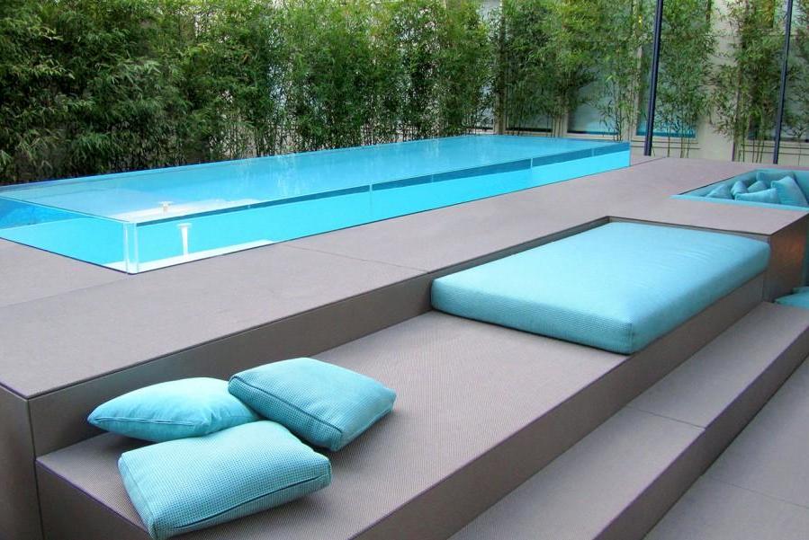 Piscine Laghetto, Isola by Laghetto, a tracimazione, con bordi trasparenti, il solarium è costituito da pannelli compositi drenanti rivestiti di tessuti di Paola lenti, soffici e molto belli. La struttura è autoportante, prefabbricata, in acciaio e l'interno di Pvc armato in diversi colori. Per un giardino o un terrazzo living, anche se non di grandi dimensioni. Facile da proteggere con una copertura su misura.