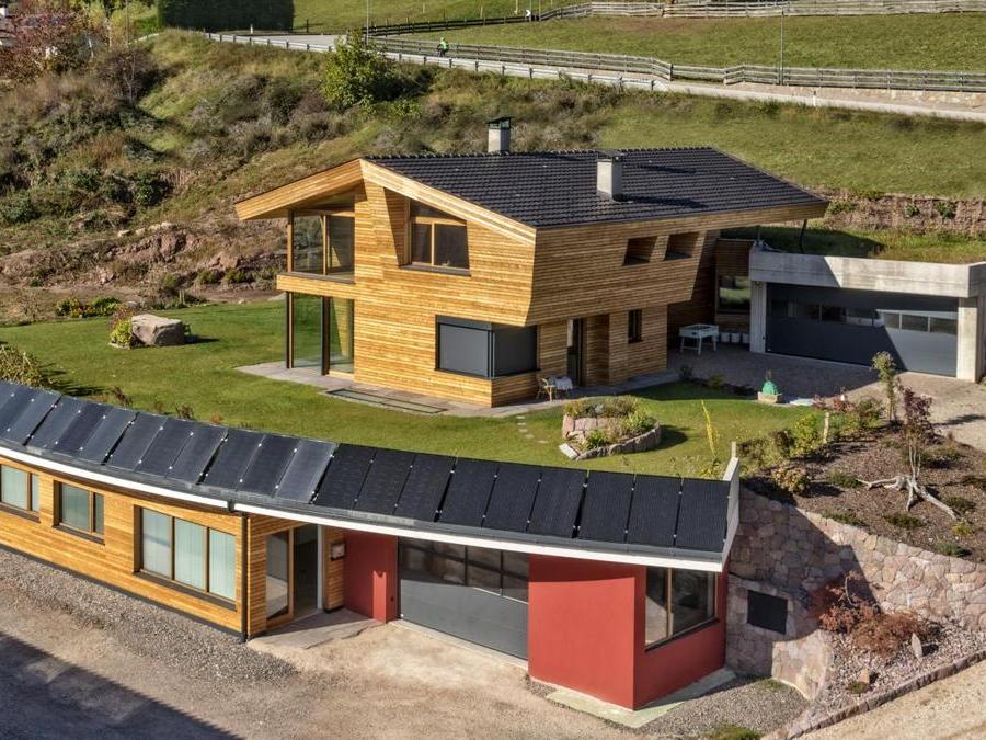 Sede aziendale e appartamento privato, San Genesio – Arch. Christine Pfeifer, Arch. Norbert Dalsass. Con certificazione CasaClima Gold, l'edificio è costruito internamente con legno e argilla e presenta un sistema di pannelli solari ibridi per la produzione di calore e corrente elettrici. Inoltre, una pompa di calore estrae l'energia accumulata da un serbatoio di acqua piovana.
