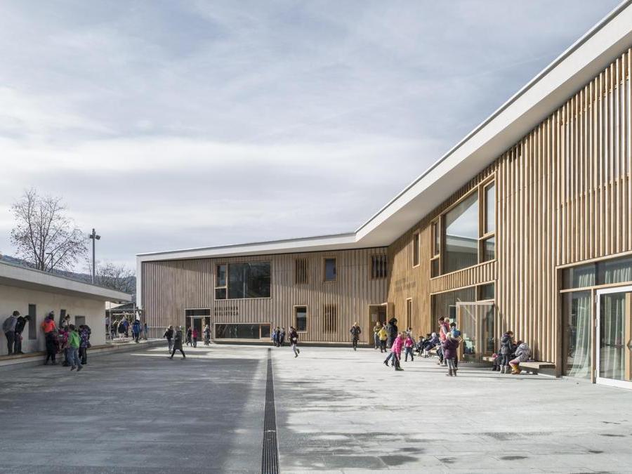 Polo scolastico, Sant'Andrea, Bressanone – MoDusArchitects. La copertura con tetto verde e l'attenzione all'illuminazione naturale per una qualità e comfort anche negli ambienti seminterrati caratterizzano l'edificio certificato CasaClima B. La struttura è rivestita a cappotto in fibra di legno ed è stata risanata con una sovrapposizione di strati isolanti.