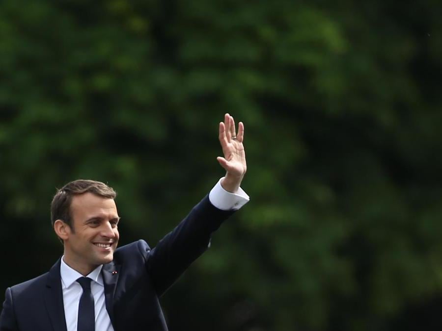 Il nuovo Presidente francese, Emmanuel Macron, durante la cerimonia del suo insediamento, mentre saluta la folla da una macchina. ( AFP PHOTO / Charly Triballeau)