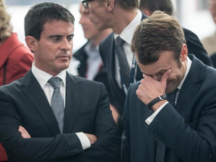 Il Primo Ministro francese Manuel Valls ed Emmanuel Macron, quando era Ministro dell’Economia, durante una visita ufficiale ad Amburgo, 22 settembre  2014. (AFP PHOTO / POOL / Axel Heimken)