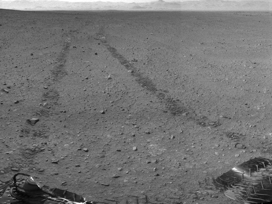 Questa immagine fornita dalla NASA / JPL-Caltech mostra i dintorni del luogo in cui la sonda Rover Mars NASA Curiosity è arrivata il 4 settembre 2012. Si tratta di un mosaico di immagini scattate dalla Curiosity's Navigation Camera (Navcam) seguendo il disco Sol 29 di 100 piedi. A circa 9 piedi di distanza, le tracce dal disco sono visibili nell'immagine. (AP Photo/NASA/JPL-Caltech)