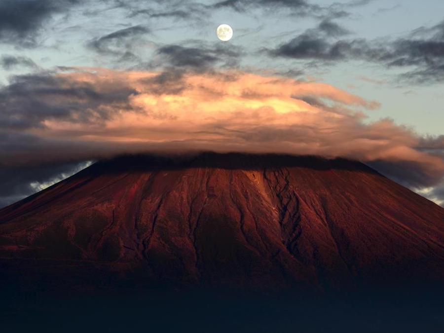 Image Name: Moon above Red Fuji. Photographer Name: Takashi Nakazawa. Year: 2018. Copyright: © Takashi Nakazawa, Japan, Commended, Open Landscape & Nature and 3rd Place, Japan National Award, 2018 Sony World Photography Awards
