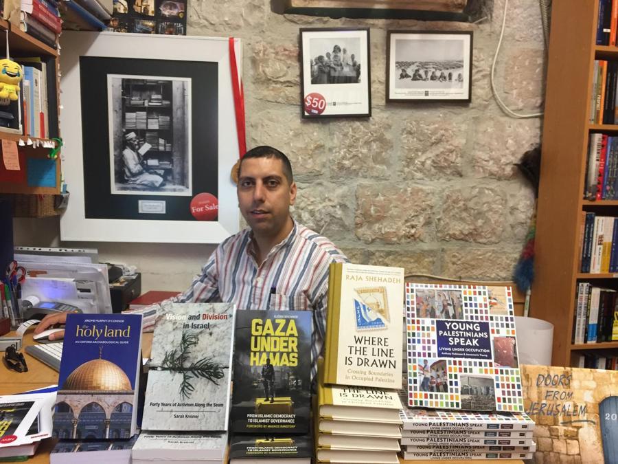 Il Bookstore, unica libreria a Gerusalemme dove si trovano in ugual numero testi filo palestinesi e filo israeliani. Oltre ai testi politici, titoli di cucina, romanzi e poesia. Dietro al banco, Mahmoud Muna, gestore, scrittore e storico. Foto di Sara Magro