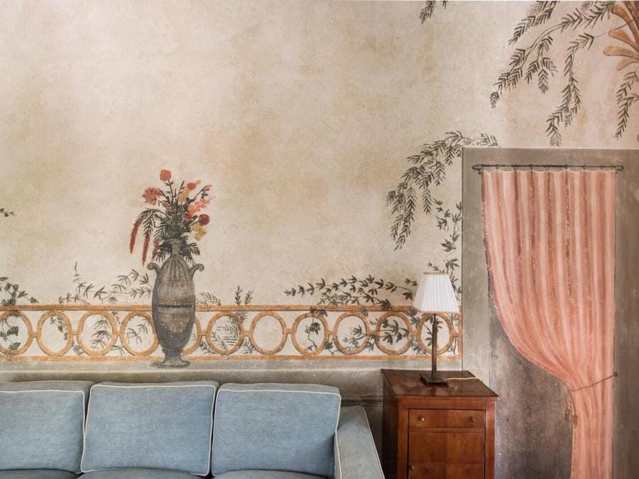 Salottino con trompe l'oeil nella canonica, che può essere prenotata come appartamento indipendente, con tre camere, salotto e cucina medievale.
