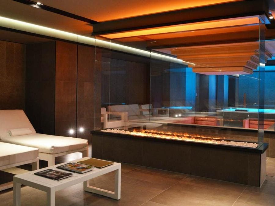 L'area benessere con sauna, hammam, idromassaggio e zona relax separata con un camino trasparente. 