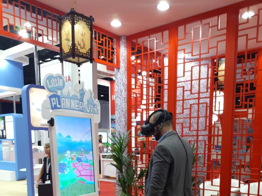 Un visitatore prova un casco VR (Realtà Virtuale) per progettare in 3D le città