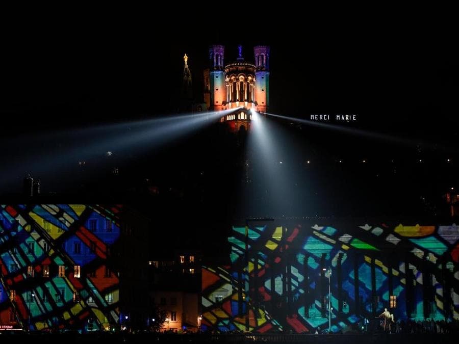 La Basilica di Notre-Dame de Fourvière e gli edifici sono illuminati durante la ventesima edizione del Festival delle Luci (Fete des Lumieres) a Lione. (Photo by JEAN-PHILIPPE KSIAZEK / AFP)