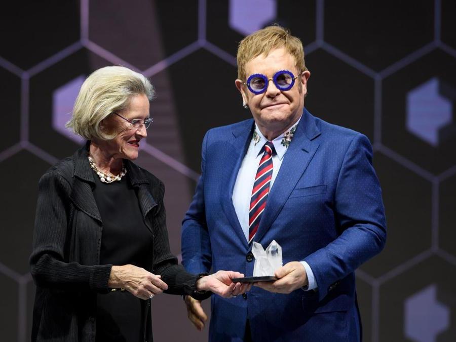 Elton John riceve il premio Crystal Award da Hilde Schwab (AFP PHOTO / Fabrice COFFRINI)