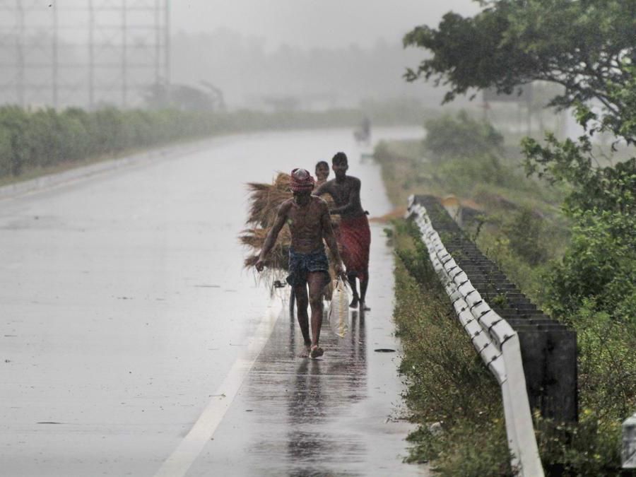 Gli abitanti del villaggio si spostano verso luoghi più sicuri, tra raffiche di vento che precedono l'approdo del ciclone Fani alla periferia di Puri, nello stato indiano dell'Odisha. (AP Photo)