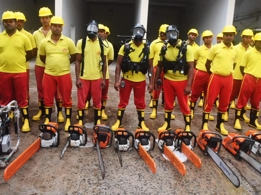 I pompieri indiani stanno accanto al loro equipaggiamento.  (Photo by Dibyangshu SARKAR / AFP)