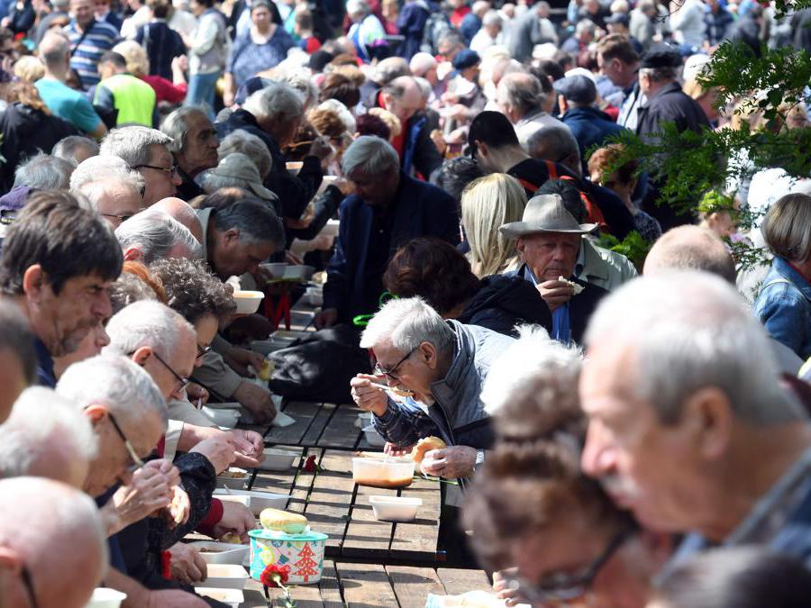 I croati mangiano un piatto di fagioli mentre altri si radunano nel parco Maksimir di Zagabria per celebrare il Primo Maggio. Molte persone, in particolare gli anziani, sfruttano l'opportunità di avere un pasto tradizionale gratuito - fagioli - distribuiti per l'occasione mentre lottano con la difficile situazione economica. (Photo by Denis LOVROVIC / AFP)