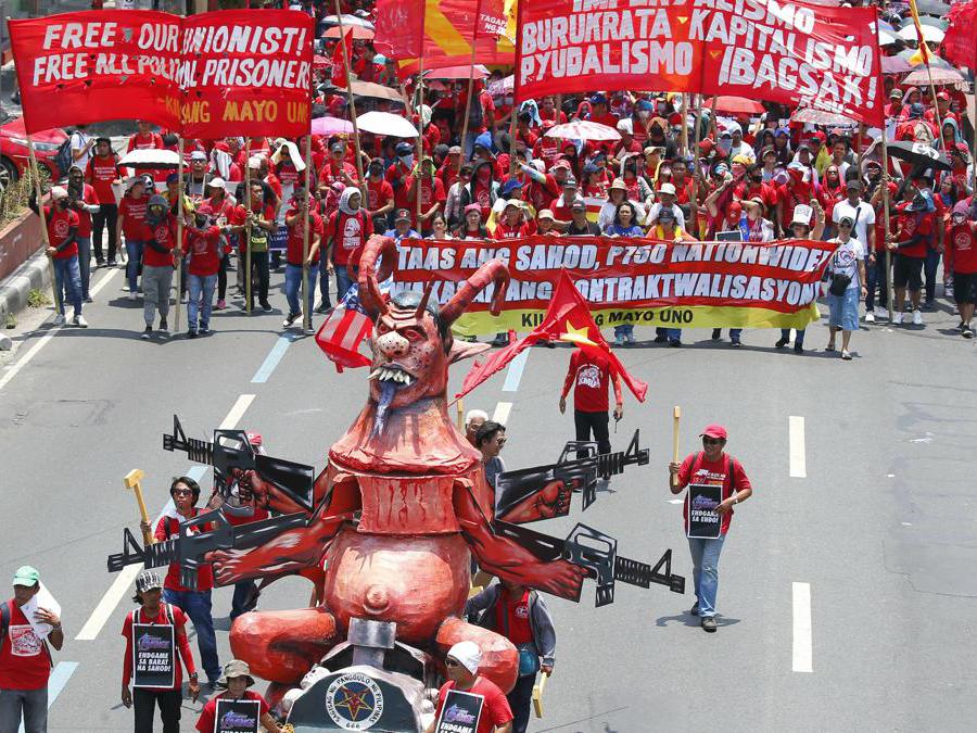 Migliaia di lavoratori marciano con un'effigie del Presidente Rodrigo Duterte verso il Palazzo Presidenziale a Manila, nelle Filippine, per rendere omaggio ai lavoratori in celebrazione della Giornata Internazionale del Lavoro. (AP Photo/Bullit Marquez)