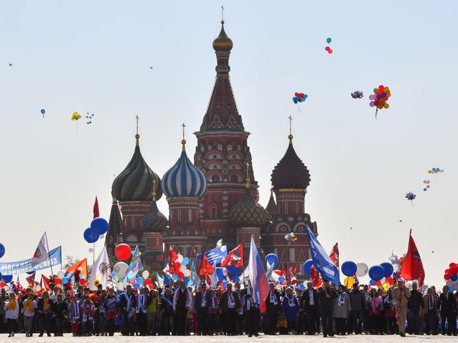 I membri dei sindacati russi che tengono palloncini, bandiere e fiori artificiali sfilano sulla Piazza Rossa durante la loro manifestazione del Primo Maggio a Mosca . (Photo by Yuri KADOBNOV / AFP)