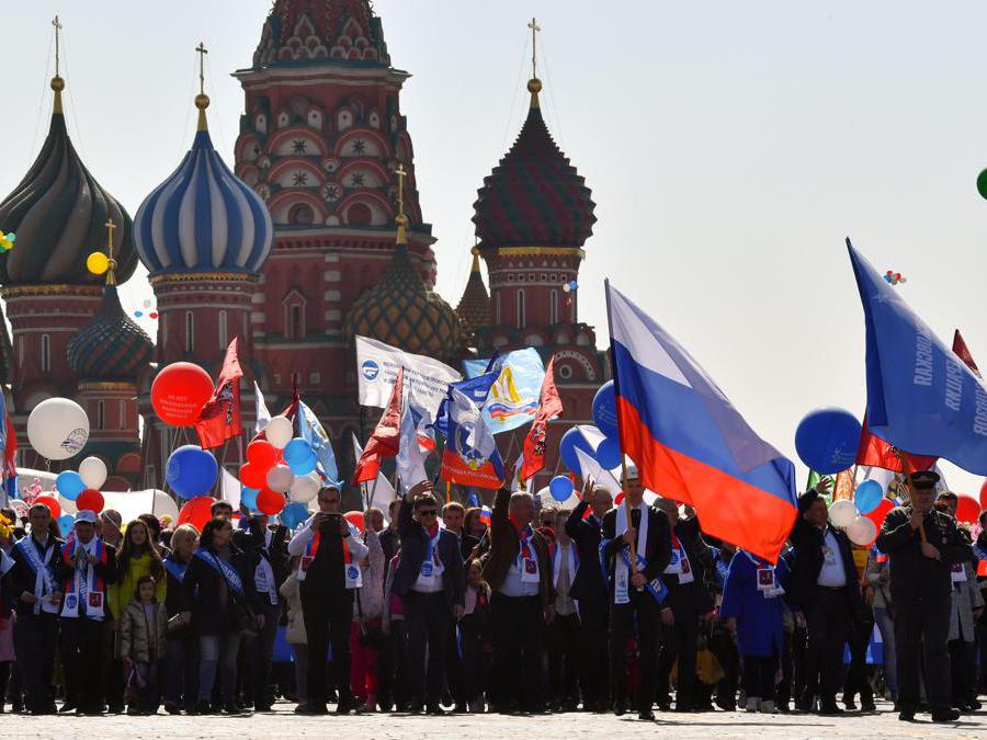I membri dei sindacati russi che tengono palloncini, bandiere e fiori artificiali sfilano sulla Piazza Rossa durante la loro manifestazione del Primo Maggio a Mosca . (Photo by Yuri KADOBNOV / AFP)