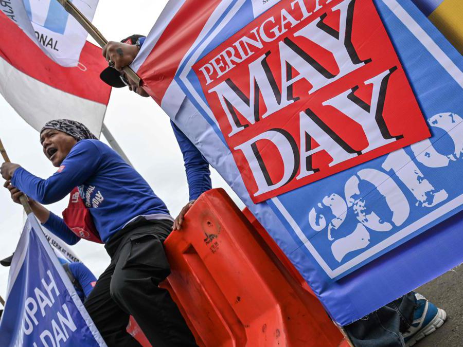 Attivisti e lavoratori indonesiani prendono parte a una protesta per celebrare il Primo Maggio a Giacarta . (Photo by BAY ISMOYO / AFP)