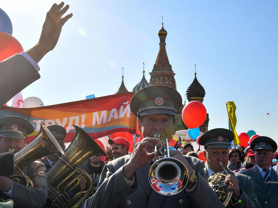 I membri dei sindacati russi che tengono palloncini, bandiere e fiori artificiali sfilano sulla Piazza Rossa durante la loro manifestazione del Primo Maggio a Mosca . (Photo by Yuri KADOBNOV / AFP)
