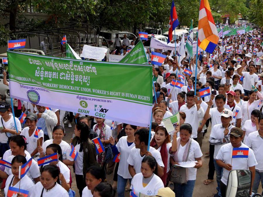 I lavoratori marciano lungo una strada per celebrare la festa internazionale del lavoro a Phnom Penh . (Photo by TANG CHHIN Sothy / AFP)