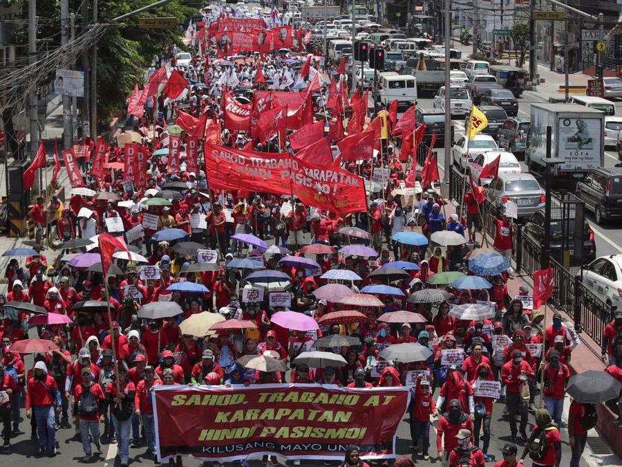 I manifestanti marciano su una strada in occasione della festa del lavoro a Manila, Filippine. EPA/FRANCIS R. MALASIG