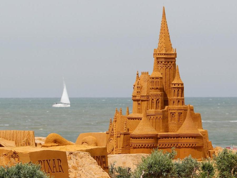 Susanne Paucker dalla Germania lavora su una scultura  durante il Festival della scultura di sabbia “Disney Sand Magic” a Ostenda. (Reuters)