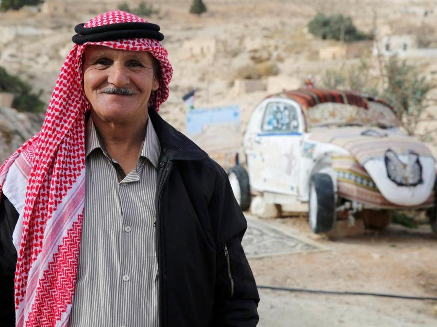 Mohammed Al-Malahim, un pensionato giordano, posa accanto al suo Maggiolino Volkswagen trasformato  in quello che lui definisce “l'hotel più piccolo del mondo” a Shoubak in Giordania. (REUTERS/Muhammad Hamed)