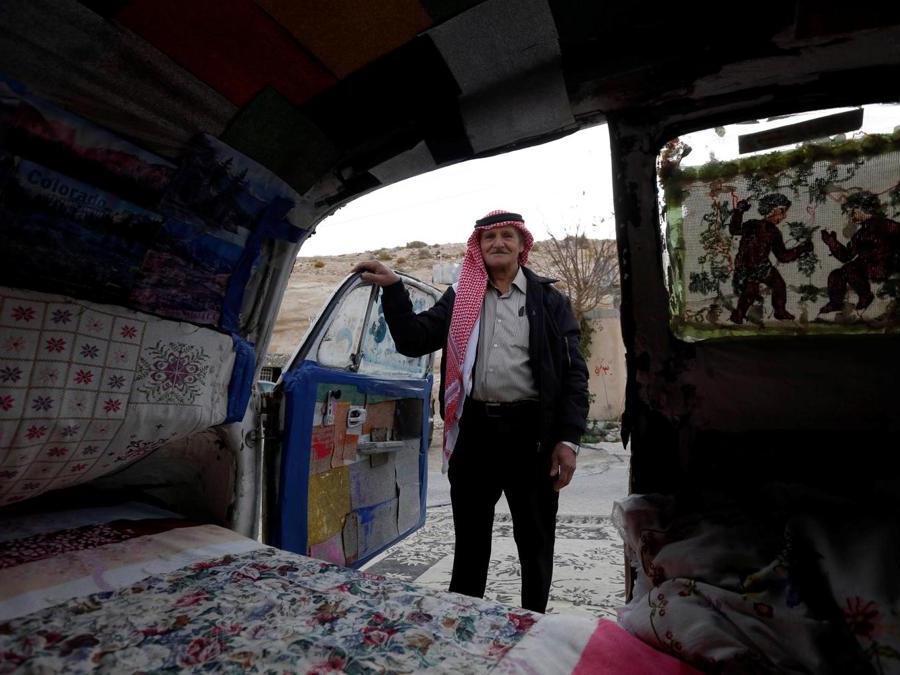 Mohammed Al-Malahim, un pensionato giordano, posa accanto al suo Maggiolino Volkswagen trasformato  in quello che lui definisce “l'hotel più piccolo del mondo” a Shoubak in Giordania. (REUTERS/Muhammad Hamed)