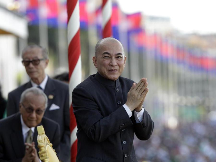 Il Re cambogiano saluta gli ufficiali governativi mentre osserva le barche che corrono sull’acqua. (AP Photo/Heng Sinith)
