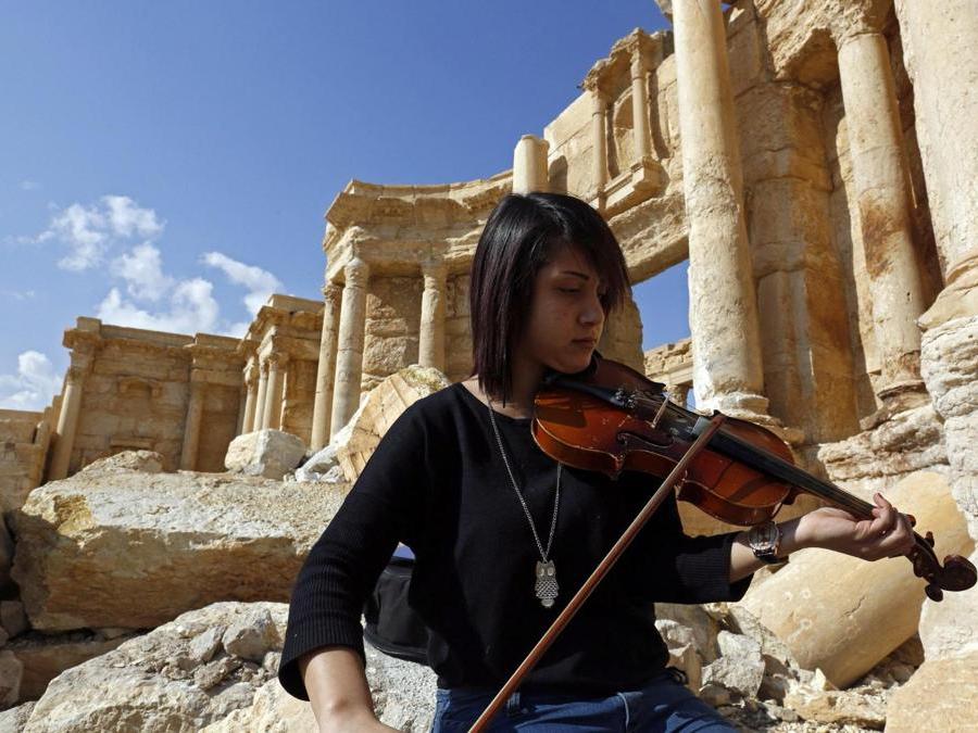 Una ragazza siriana suona il violino nella città storica di  Palmyra. (EPA)