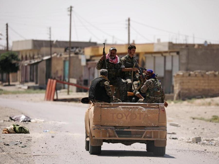 Le forze democratiche siriane (SDF)  su un autocarro lungo una strada nel quartiere occidentale di Raqqa. (REUTERS/Rodi Said)