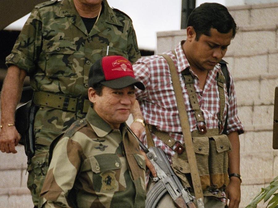 Il generale Manuel A. Noriega, lascia le sedi delle forze di difesa a Panama City, accompagnato da un membro dell'unità militare di lotta per la giungla, chiamata “Machos De Monte”. (AP Photo/John Hopper, File)