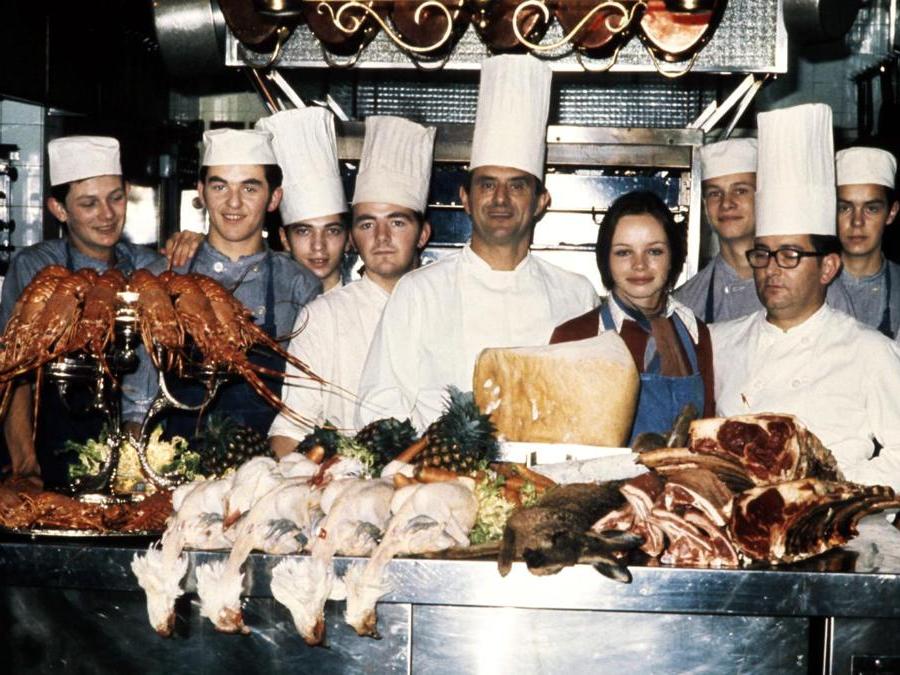 Questa foto di archivio scattata il 15 novembre 1973 mostra lo chef francese Paul Bocuse (centro)  nella sua cucina con il suo staff  a Lione. (Afp)