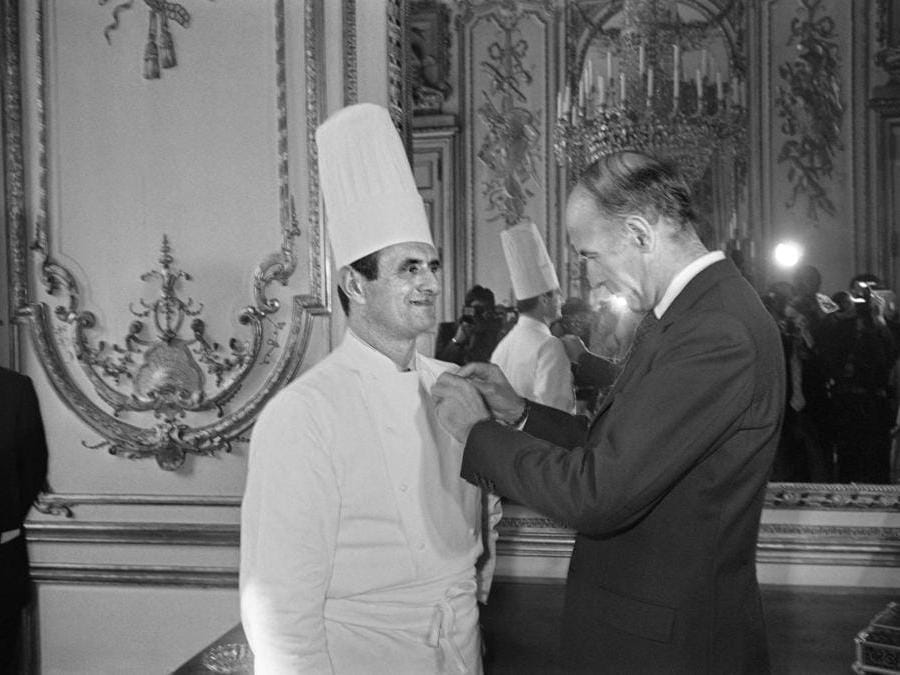Questa foto di archivio scattata il 25 febbraio 1975 mostra il presidente francese Valery Giscard d'Estaing (destra) mentre premia  lo chef francese Paul Bocuse con la Legion d'Honneur all'Eliseo di Parig. (Afp)